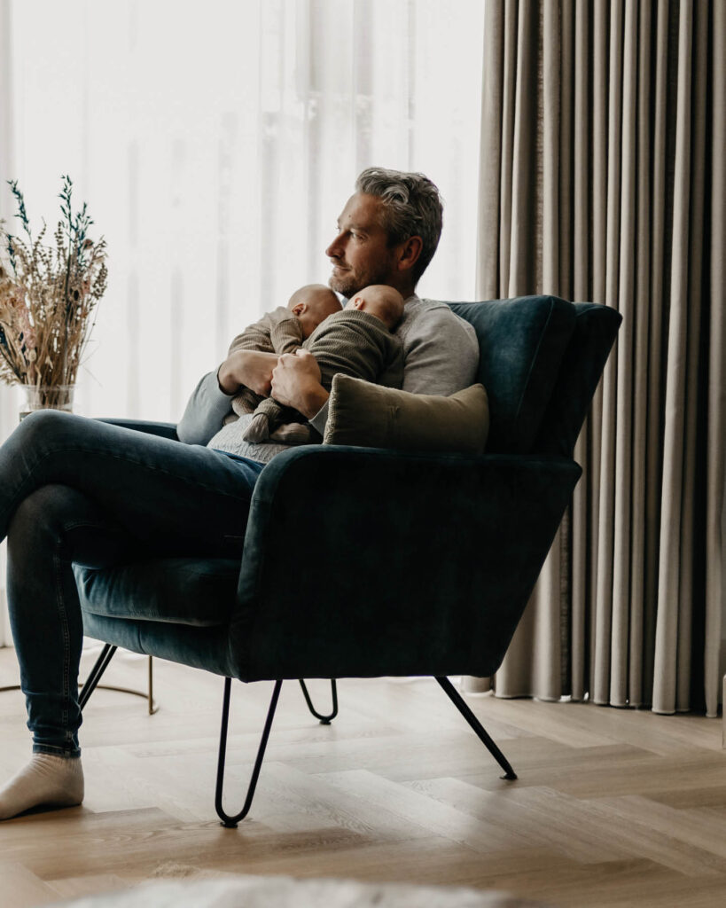 Ontroerende newborn fotografie van een pasgeboren tweeling door Evelien Thijssen. Puur, liefdevol en tijdloos vastgelegd in een warme lifestyle setting.